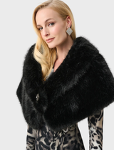 Stylish black cover-up laid flat, emphasizing its simple lines and potential for layering in various outfits.