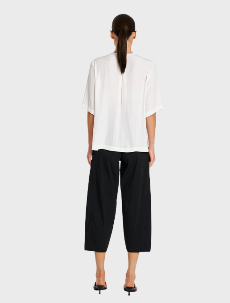 Black cropped Tuscan pants featured prominently, emphasizing their contemporary style and elegant silhouette.