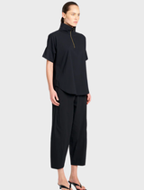 A pair of black cross pants laid flat, featuring a contemporary cut ideal for casual or formal wear.