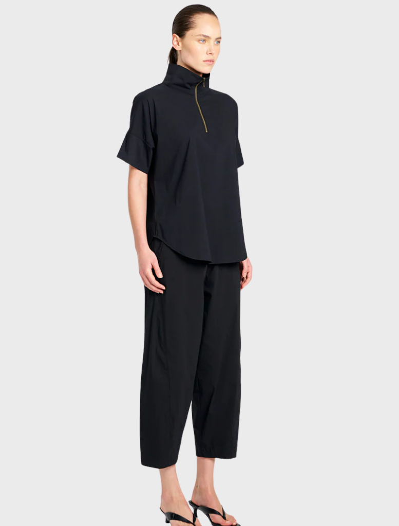 A pair of black cross pants laid flat, featuring a contemporary cut ideal for casual or formal wear.