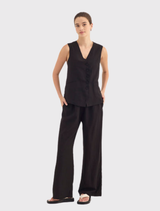 Elegant black vest with a V neckline, curved button front, and back V-panel detail, perfect for layering or wearing alone.