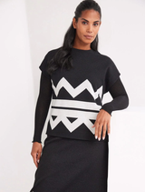 A black and ecru zigzag top hanging, showcasing its unique geometric design and color contrast.