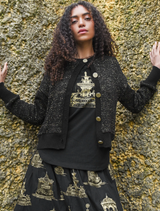 Black and gold Shine Of The Times cardigan displayed on a hanger, featuring a stylish, shimmering design.