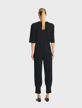 Black jet pants laid flat, highlighting their contemporary cut and fabric texture for a stylish wardrobe choice.