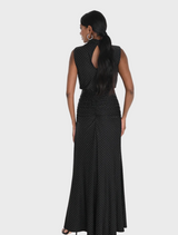 Elegant black dress adorned with white polka dots, showcasing a classic silhouette, hanging against a light backdrop.