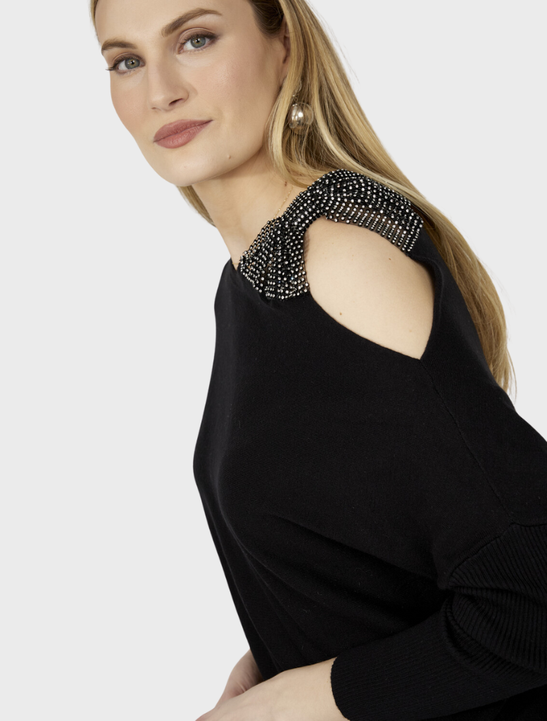Black knit top laid flat, emphasizing its smooth fabric and elegant simplicity, perfect for various occasions.