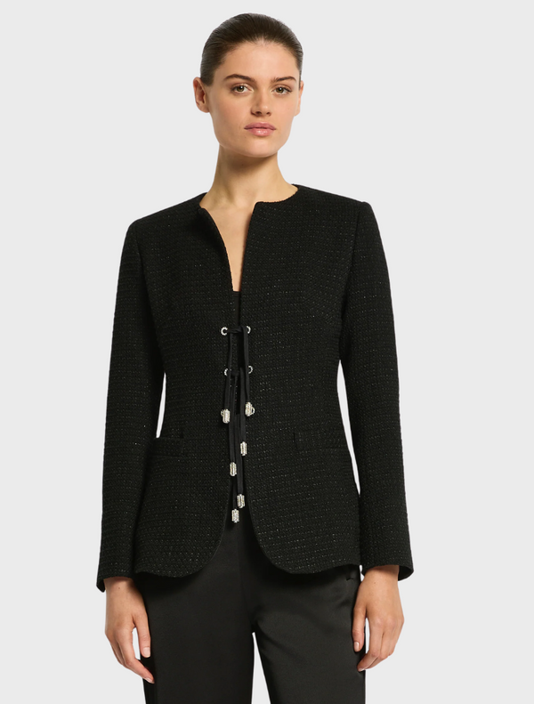 A woman dressed in a black suit and shorts, exuding professionalism and style.