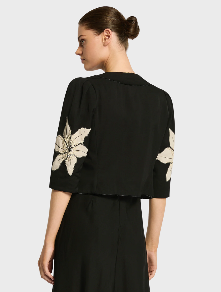 Front view of a black Nikita jacket, showcasing its stylish cut and fabric texture.