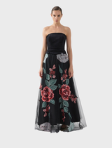 The Olympia skirt in black rose pattern, elegantly draped on a hanger for display.