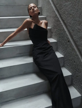 Sophisticated black strapless dress with a tailored fit and elegant draping, suitable for special occasions.