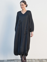 Elegant black dress adorned with sparkles, designed for evening wear, showcasing a fitted style and sophisticated appeal.