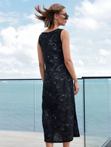 Black dress adorned with shimmering sequins, side splits, and a soft silhouette, perfect for a layered outfit.