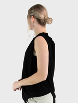Black Stine top presented on a hanger, emphasizing its contemporary cut and fabric quality.