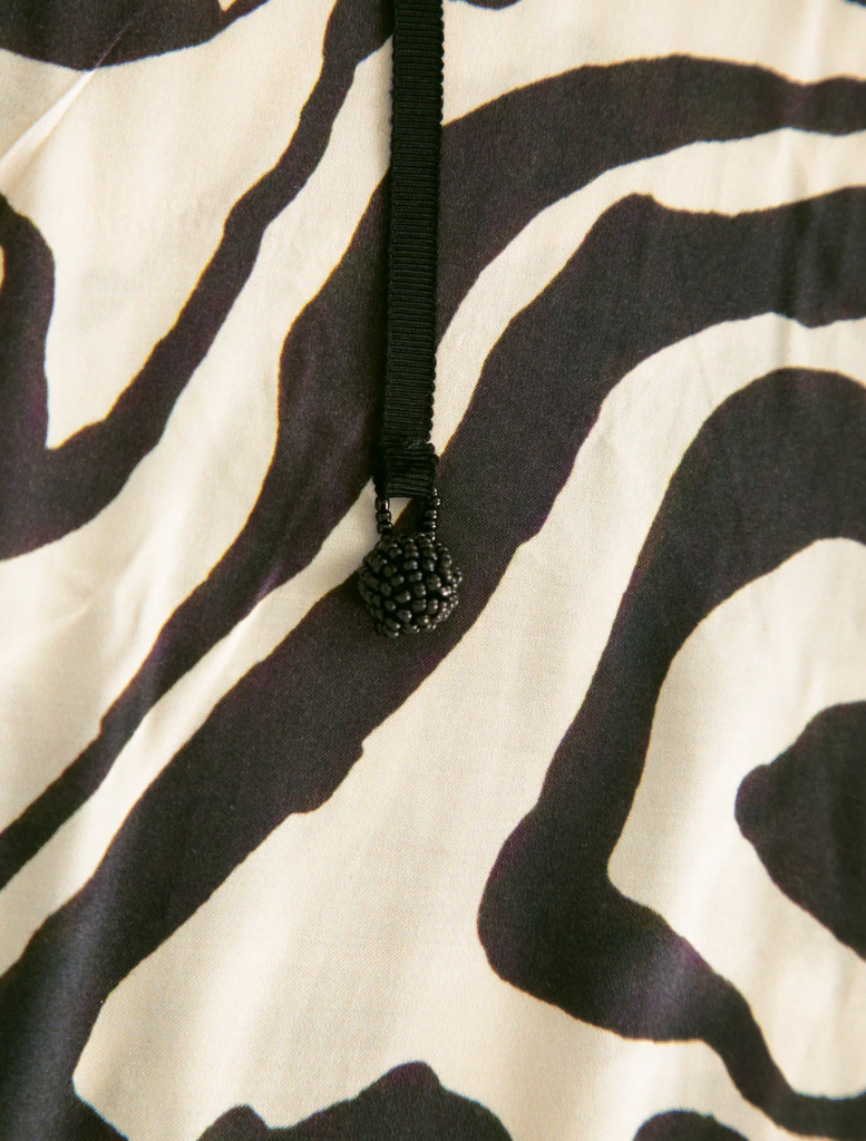 Black and stone dress featuring a modern design, suitable for various occasions. Elegant and stylish for any wardrobe.