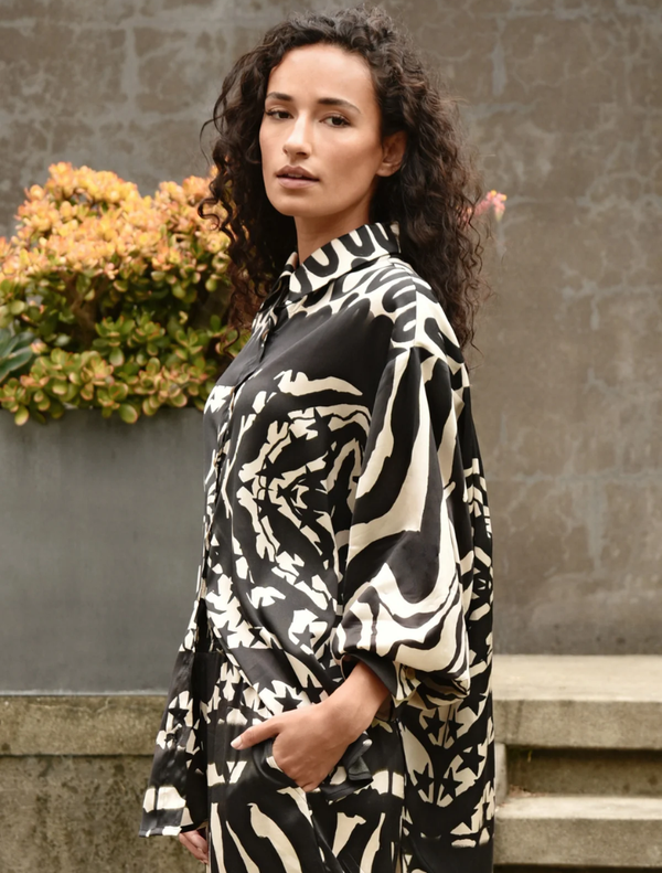 A black and stone casual shirt laid flat, featuring a simple, stylish design suitable for everyday wear.