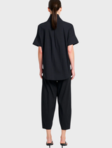 Sleek black cross pants presented, emphasizing their tailored fit and suitability for both casual and professional settings.