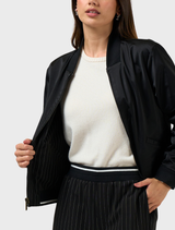 The image features a black Trax reversible jacket, emphasizing its stylish design and functional versatility.