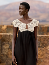 Flowing black and white dress made of viscose georgette, adorned with an ecru lace bib, offering a romantic design.