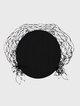 Morgan & Taylor's black Zahra Pillbox Hat, showcasing a classic shape and elegant veiling for formal occasions.