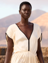 Elegant ecru dress with Greco-Roman inspiration, V-neck, black bias binding, and adjustable back tie for a perfect fit.