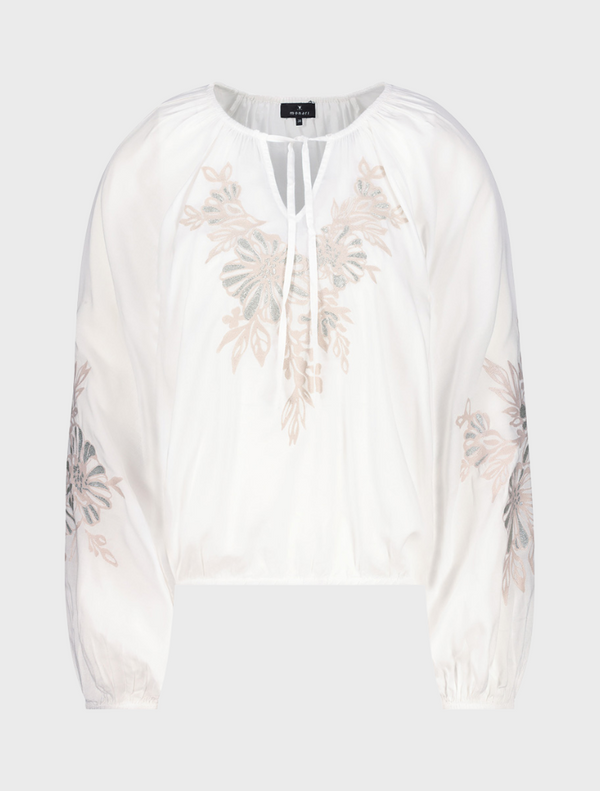 White blouse featuring colorful embroidered flowers on the front, showcasing a delicate and stylish design.