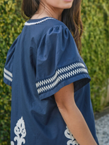 A blue Border Control Top hanging, highlighting its modern style and clean lines.