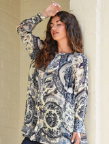 Feminine blue shirt featuring a swing bodice, flared panels, and button front, made from soft viscose georgette.