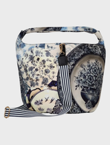 Versatile blue FULL VOLUME Bag with a sculptural base, drawcord closure, and adjustable striped strap for crossbody or shoulder wear.