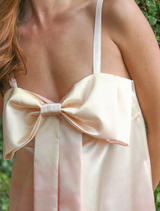 A beautiful dress in shades of sunset, highlighted by a bow detail at the waist, suitable for various events.