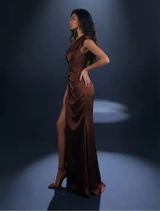 Timeless bronze gown showcasing a one-shoulder neckline, pleated floor-length skirt, and high leg split for added elegance.