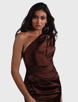 Bronze gown featuring a one-shoulder design, fitted bodice, pleated skirt, and high leg split, perfect for formal occasions.