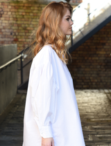 White cotton shirt with 'C You Soon' design, drop shoulder, blouson sleeves, and embroidered 'Cooper' pocket for modern appeal.