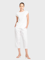 A cozy café with white walls, wooden furniture, and warm lighting, inviting patrons to relax and enjoy their drinks.