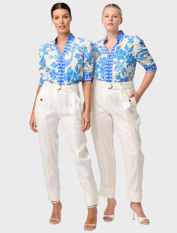 Two women in white pants and blue Calantha Viscose Dobby shirts stand together, smiling against a neutral background.