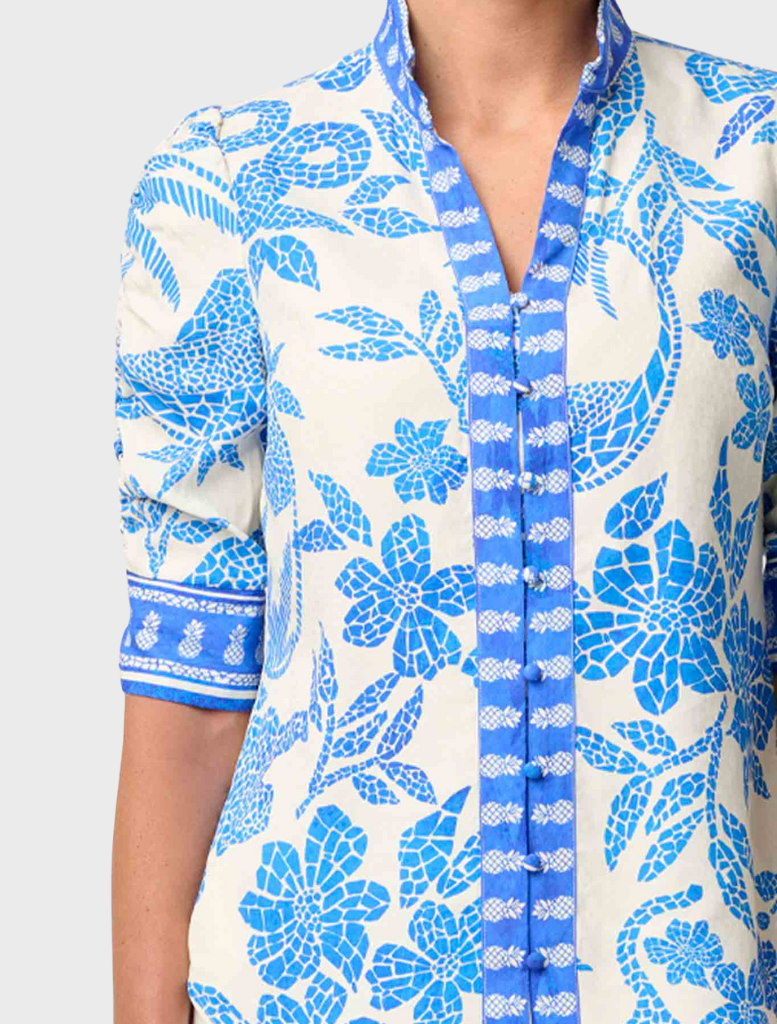 A woman dressed in a blue and white shirt featuring rouched sleeves, identified as the Calantha Viscose Dobby style.