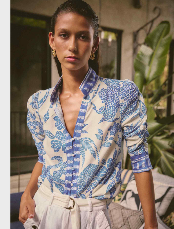 A woman wearing a blue and white Calantha Viscose Dobby Ruched Sleeve Shirt in Azure Mosaic pattern.
