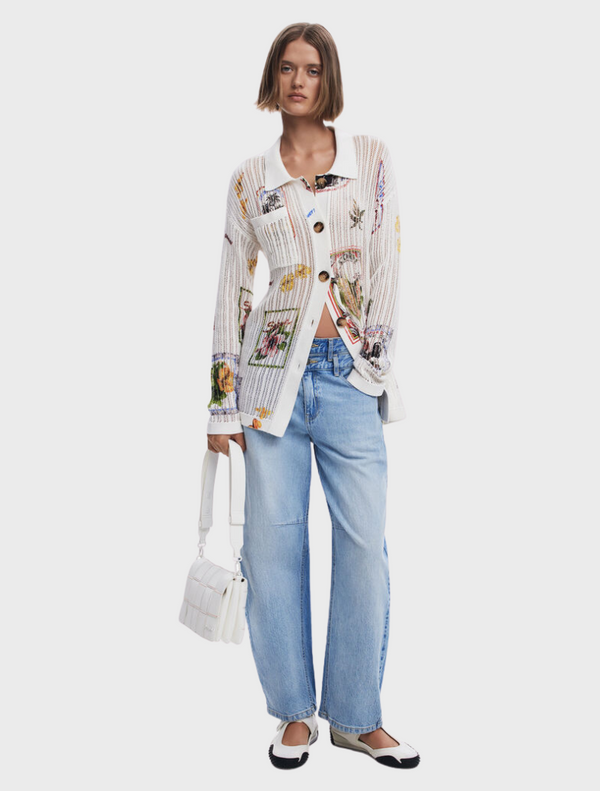 The model is dressed in a white shirt featuring a colorful floral design.