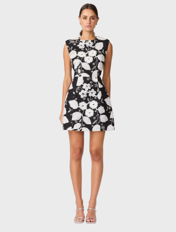 Black and white floral dress designed to resemble a blooming flower, showcasing intricate petal-like patterns.