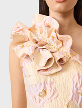 Elegant cream Carys Midi Dress with floral jacquard, asymmetrical design, ruffles, and a front split for graceful movement.