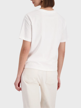 Off-White T-shirt featuring a minimalist design, paired with stylish sneakers for a casual look.