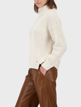Cozy almond chenille sweater on a hanger, emphasizing its warm texture and stylish appearance.