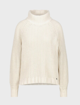 Almond-colored chenille sweater displayed on a hanger, showcasing its soft texture and cozy design.