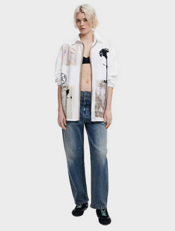 The model displays a white shirt adorned with an abstract pattern, emphasizing contemporary style and creativity.