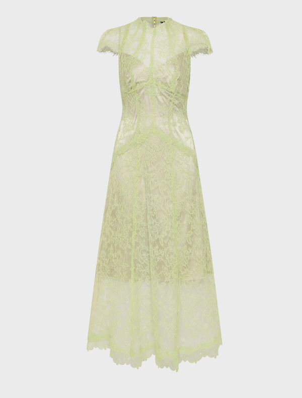 In a lush garden, a woman wears a citrus lace midi dress, showcasing elegance amidst colorful floral surroundings.
