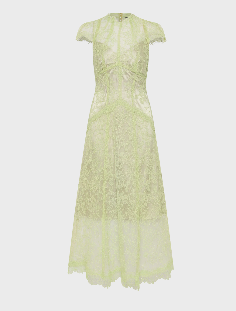 In a lush garden, a woman wears a citrus lace midi dress, showcasing elegance amidst colorful floral surroundings.
