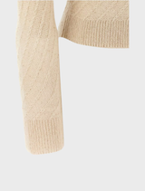 Close-up of a beige knit cardigan, emphasizing its intricate knit pattern and comfortable fit for casual outfits.