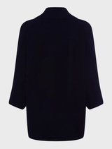 A black knit cardigan, highlighting its soft texture and classic style, set against a navy backdrop.
