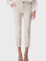  The model is dressed in a stylish white blouse and white pants, highlighting a clean and sophisticated look.