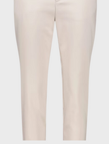 The image features a model in a white blouse and white pants, exuding a polished and contemporary style.