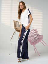 Wide leg navy and white pant featuring an elastic waist, flat front, adjustable ties, and side seam contrast tape detail.